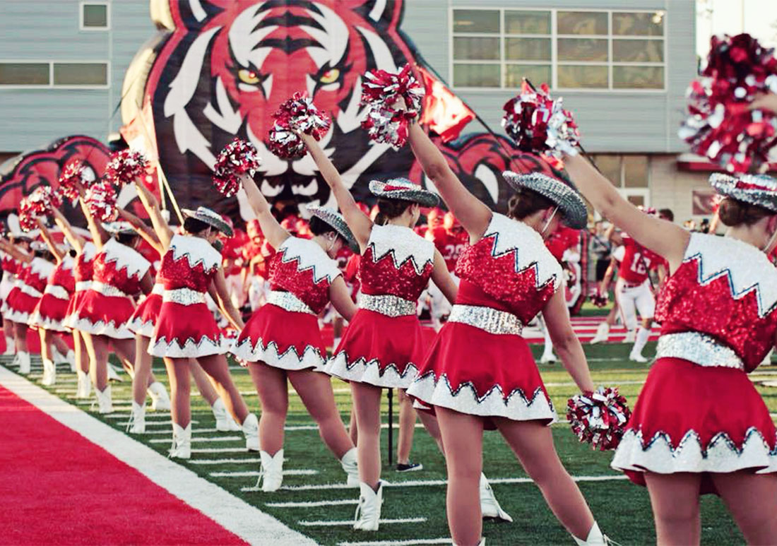 Cheerleaders posing with pompoms during a football game