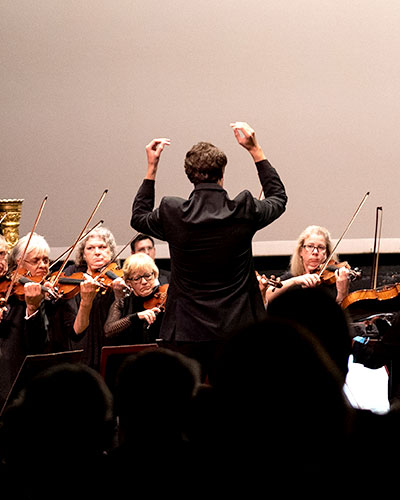 A conductor conducting an orchestra