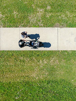 Top-down view of a couple walking a baby stroller on a side walk