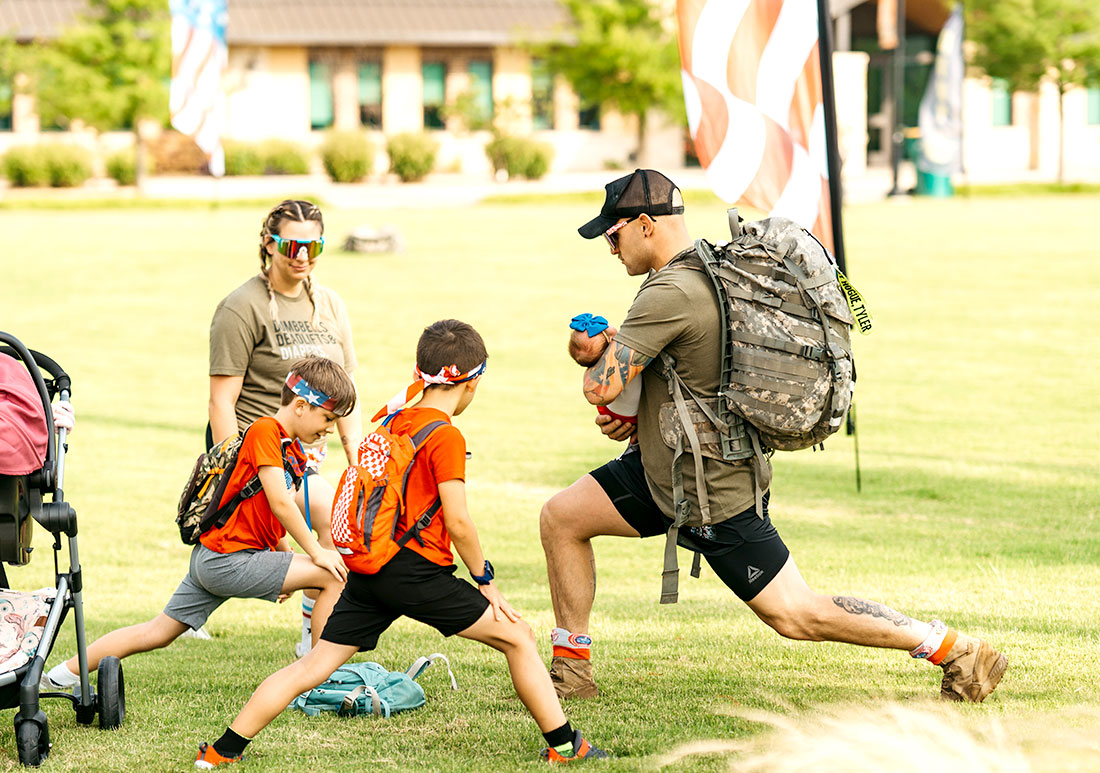 Veteran and his family warming doing lunge stretches