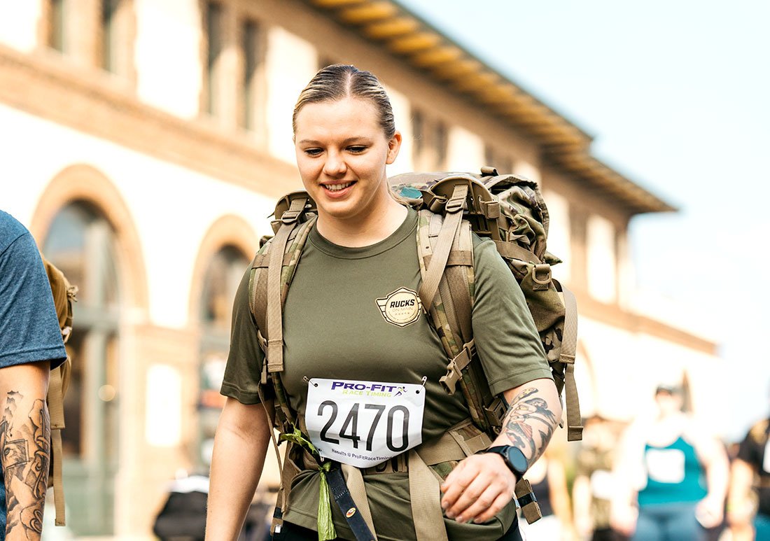 Woma in military uniform with marathon runner tag walking