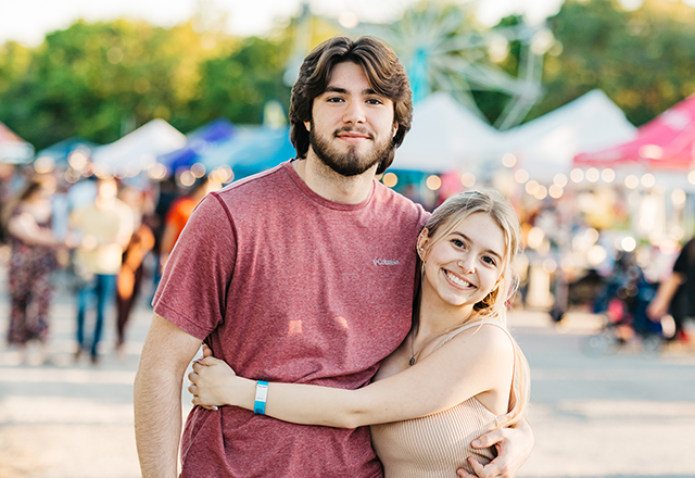 Young couple embracing within a state fair