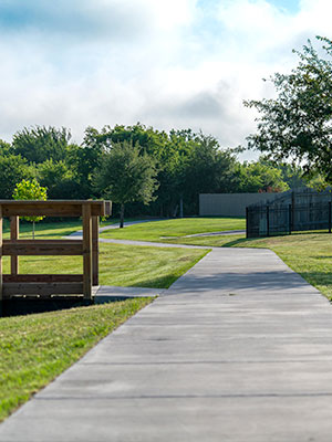 A sidewalk that runs through a neighborhood on a clear day