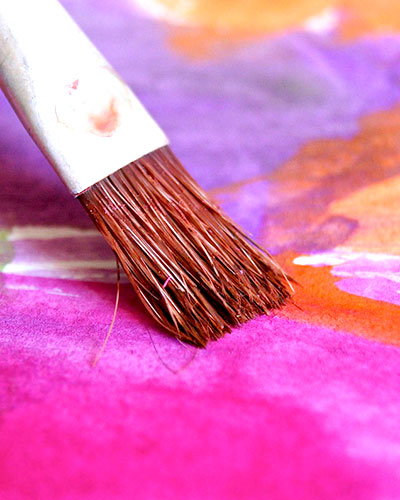 Closeup shot of a paint brush on a watercolor painting