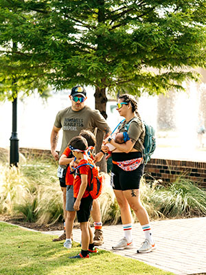 A veteran and his family stand next to a lake under a tree