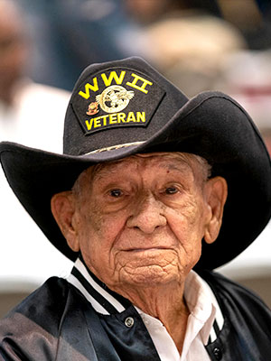 Elderly veteran with a cowboy hat with the words "WWII Veterean" on it