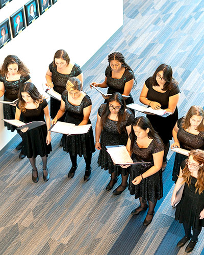 Overhead shot of a group of choir women singing in a hallway