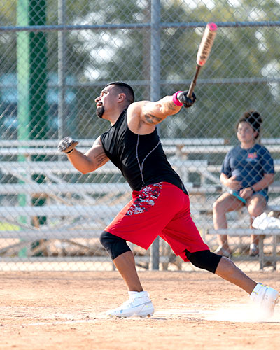 Man hitting a baseball mid swing