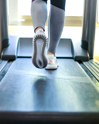 Low shot of a woman's shoes walking on a treadmill