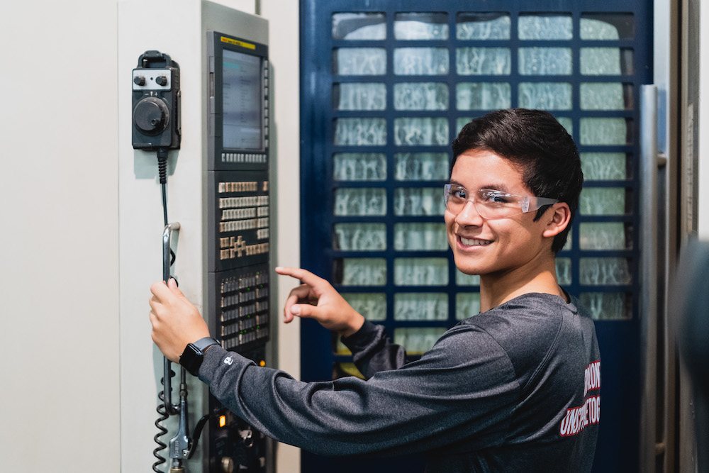 Manufacturing employee smiles at the camera